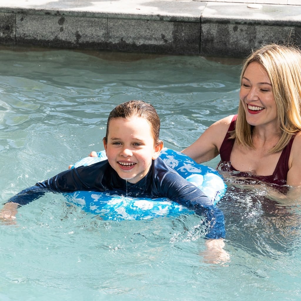 Family in pool with child using the Wahu Junior Swim Ring 4+ Years 15-25Kg