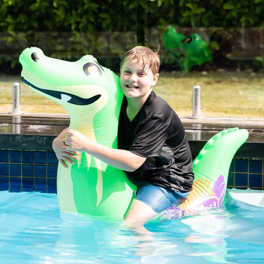 Child in pool on the Wahu Pool Pets Croc Racer