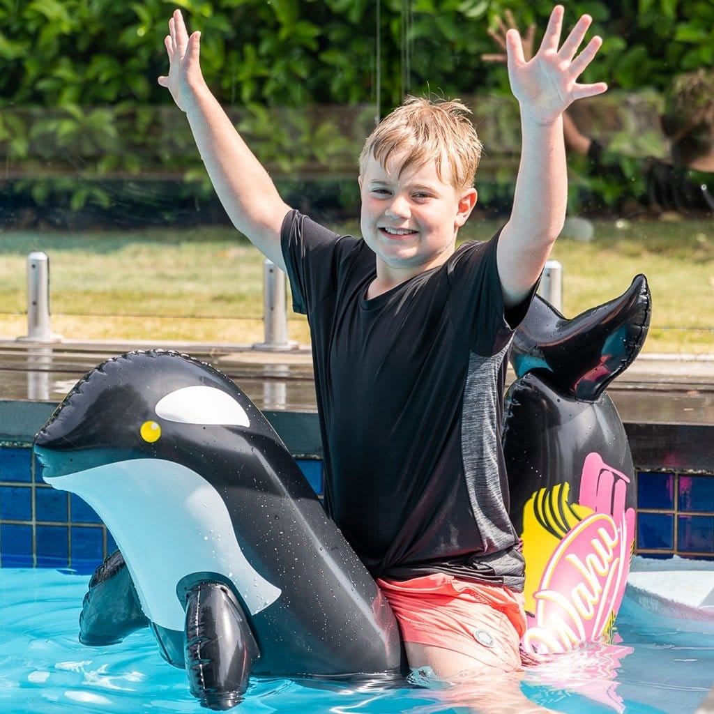 Child in pool on the Wahu Pool Pets Orca Racer